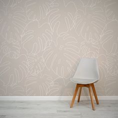 a white chair sitting in front of a wall with a pattern on it's side