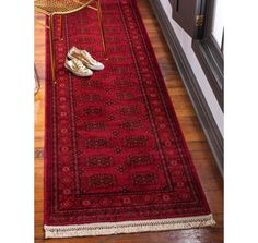 a pair of shoes sitting on top of a red rug next to a chair and door