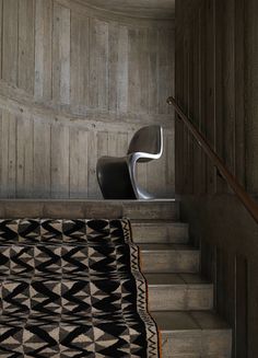 an image of a bed in the middle of stairs with a black and white bedspread on it