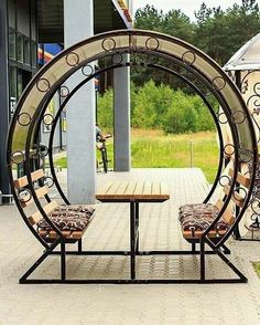 a chair sitting in front of a table on top of a metal frame with the letter a underneath it