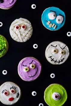 decorated cookies with faces and eyes on black background