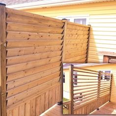 a wooden fence next to a yellow house