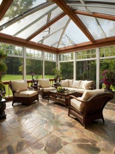 a living room filled with furniture and lots of windows on top of the roof area