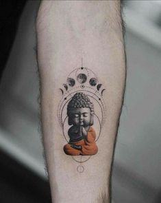 a small buddha tattoo on the arm