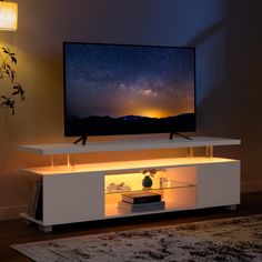 a flat screen tv sitting on top of a white entertainment center