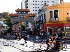 many people are walking on the street near buildings