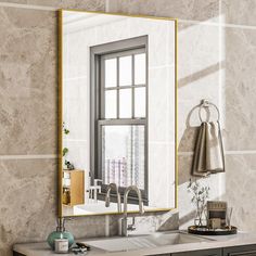 a bathroom sink sitting under a large mirror next to a wall mounted faucet