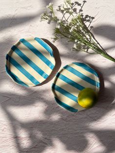 two blue and white striped plates next to a green lemon