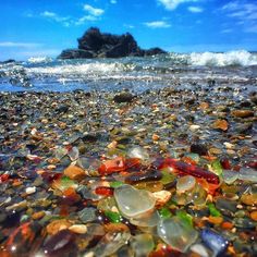 the beach is covered with many different colored glass pebbles