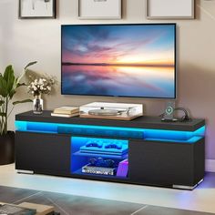 a flat screen tv sitting on top of a black entertainment center in a living room