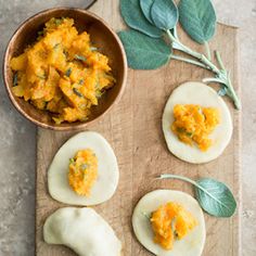 the food is prepared and ready to be eaten on the cutting board with sage leaves