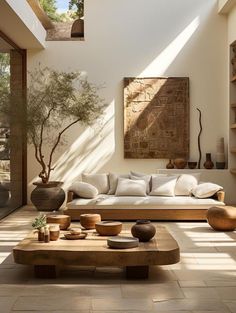 a living room filled with lots of furniture and decor on top of wooden tables in front of windows