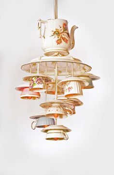 a chandelier with tea cups and saucers hanging from it's sides