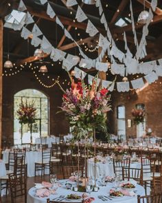 the tables are set with white linens and floral centerpieces for an elegant wedding reception