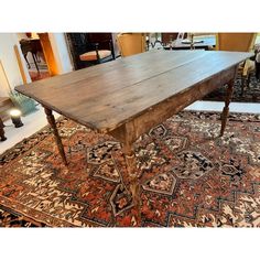 an old wooden table sitting on top of a rug