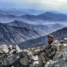 a man sitting on top of a rocky mountain