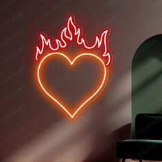 a neon heart with flames in the middle on a wall next to a green chair