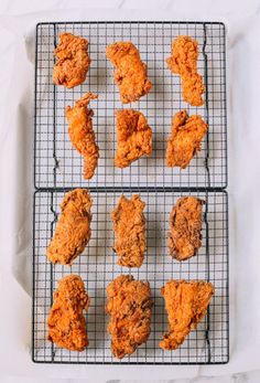 several trays of fried chicken sitting on top of a white tablecloth next to each other