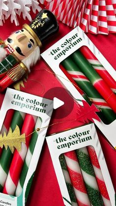 christmas crackers and candy canes are arranged on a red table with holiday decorations