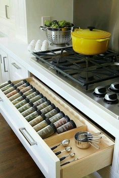 an open drawer in the middle of a stove with utensils and bowls on it