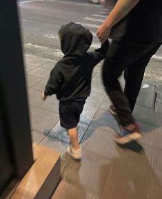 a man holding the hand of a small child