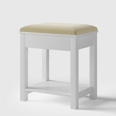 a white stool with a tan seat cushion