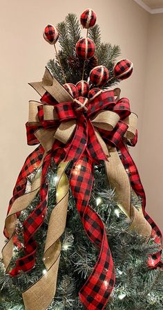 a christmas tree decorated with red and black plaid ribbon