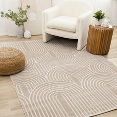 a living room with a white chair and rug on the floor next to a wooden table