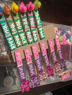 there are many candy sticks on display in the plastic case with pink and purple candies