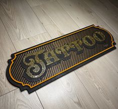 a black and gold sign with the word chicago on it's side sitting on a wood floor