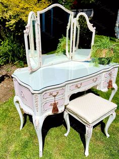 an antique vanity with mirror and stool in the grass