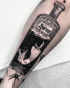 a man's arm with a bottle tattoo on it