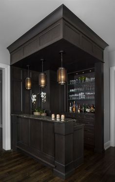 a kitchen with dark wood cabinets and marble counter tops, along with an island in the middle