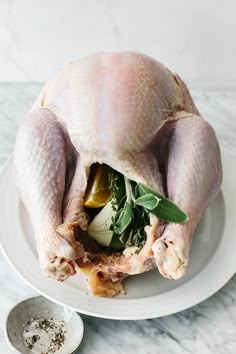 a whole chicken sitting on top of a white plate