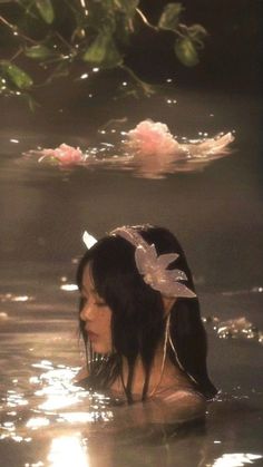 a woman in the water with flowers on her head