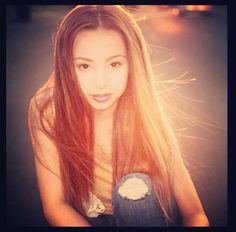 a girl with long hair and jeans posing for the camera