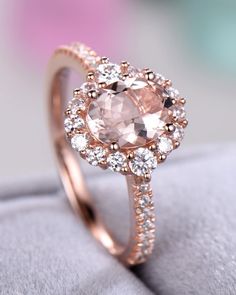 an engagement ring with a pink stone surrounded by white and rose gold diamonds on top