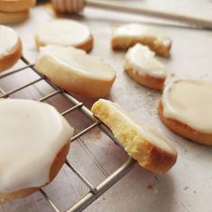 a bunch of doughnuts that are sitting on a cooling rack with icing