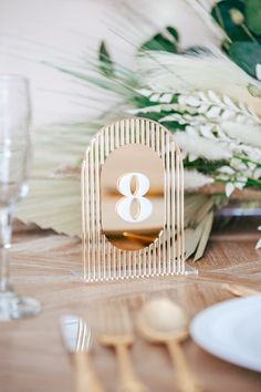 the table is set with gold and white place settings