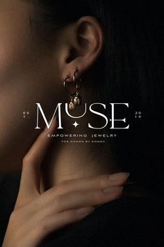 a close up of a person wearing earrings with the word muse on it