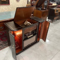 an old fashioned radio sitting on top of a wooden cabinet in a room filled with furniture