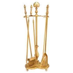 a gold plated metal stand with three brooms and two mop's