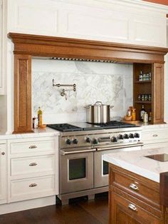 a stove top oven sitting inside of a kitchen next to white cupboards and counter tops