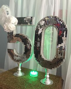 the number 50 is lit up in front of a window with white flowers on it