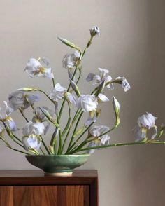 a green bowl with white flowers in it