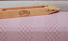 a piece of wood sitting on top of a pink and white fabric covered table cloth