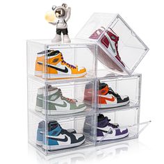 a stack of four clear acrylic boxes filled with different types of nike shoes