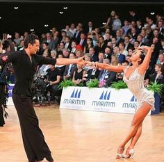 two people dancing on a dance floor in front of an audience