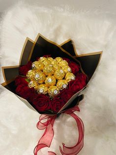 a bouquet of roses and chocolates on a white furnishing