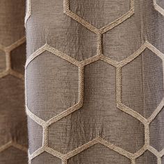 close up view of the back side of a brown and beige patterned curtain with hexagonal pattern